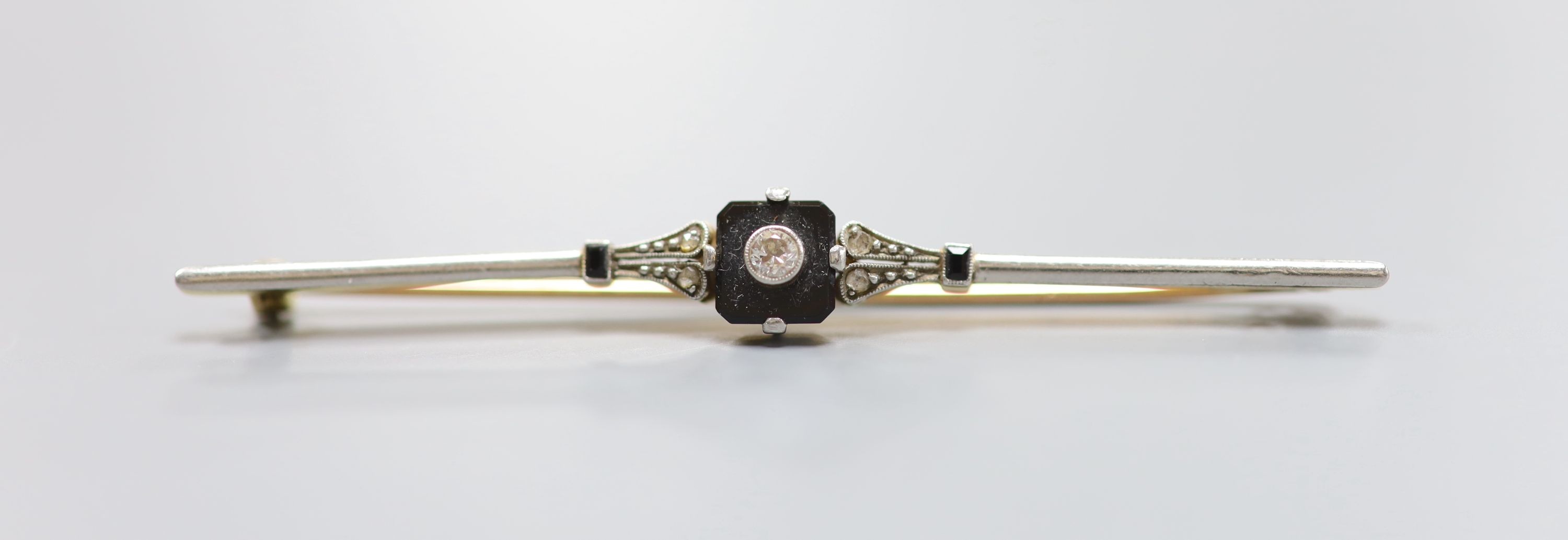 An early 20th century 18ct & plat, black onyx and diamond set bar brooch, 67mm, gross weight 5.2 grams.